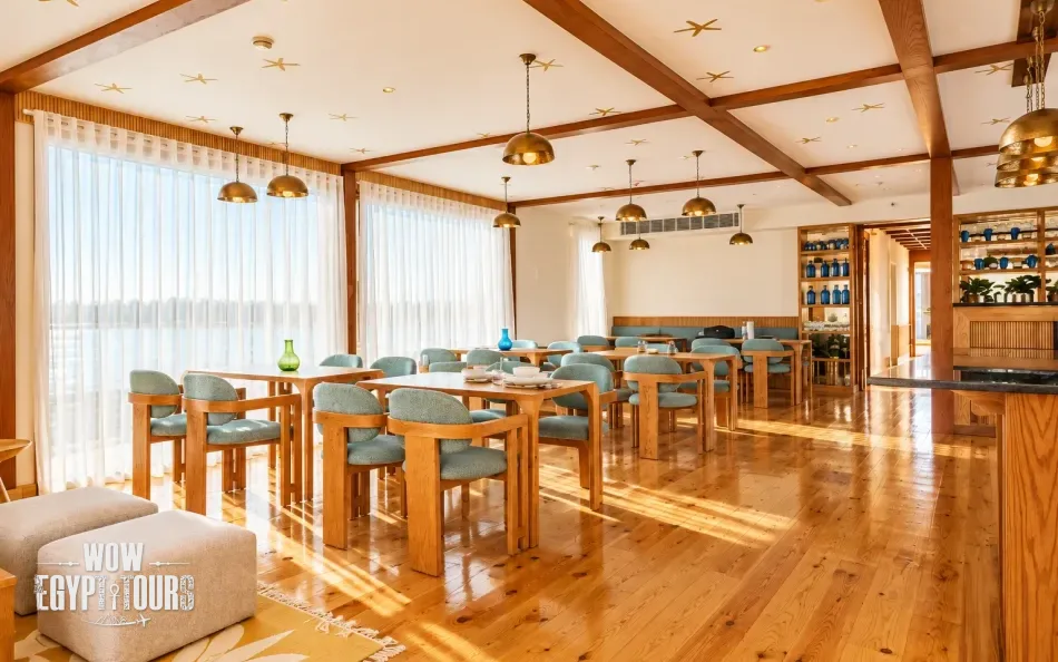 Dining area with tables and Nile River views aboard Per Ba Merkaba Dahabiya Nile Cruise