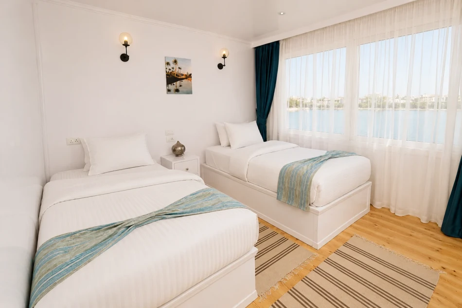 Twin cabin with two separate beds and Nile views aboard Turquoise Dahabiya Nile Cruise