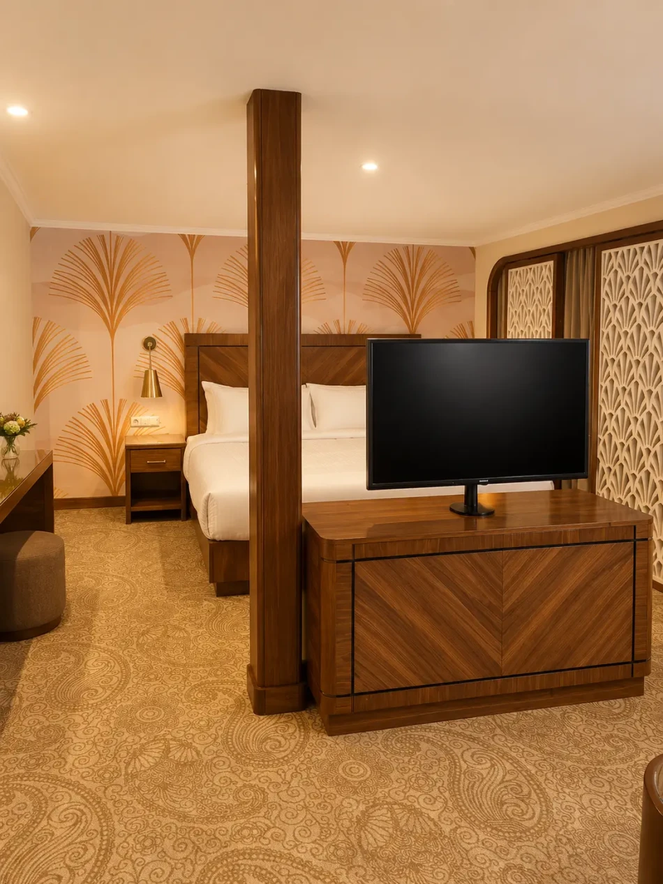 Suite bedroom with a double bed and television aboard Radamis I Nile Cruise