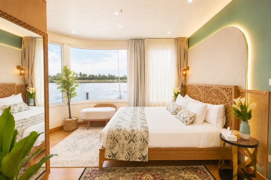 Spacious panoramic suite with bedroom and seating area aboard Nayera Dahabiya Nile Cruise